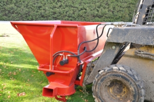 A skid steer loader with a new sawdust blower attached.